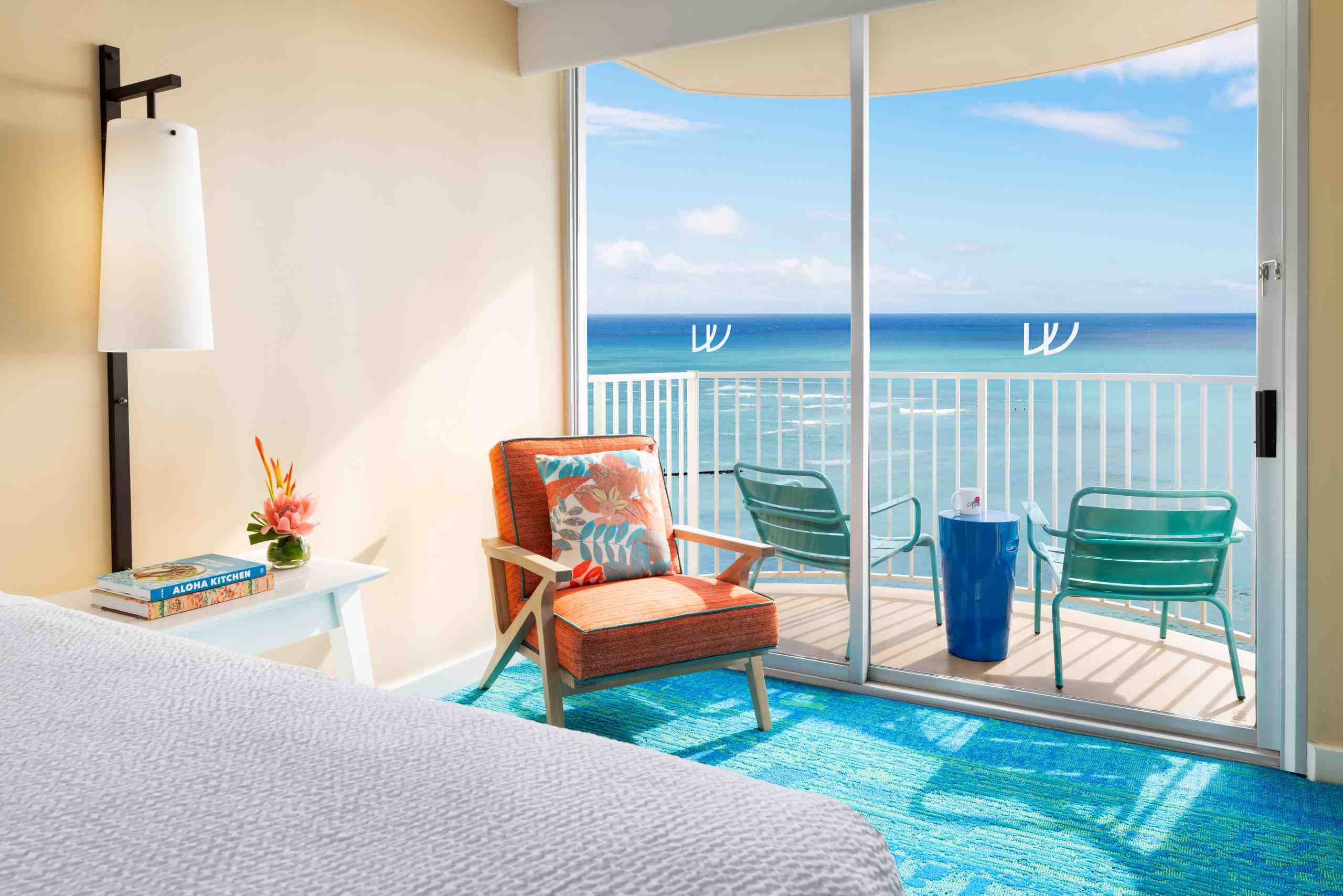 Twin Fin's bedroom with a breathtaking Honolulu ocean view and a cozy chair for relaxation.