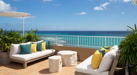 A beautiful sunset over a calm ocean with vibrant orange and pink hues reflecting on the water at the Coconut Club in the Twin Fin Hotel