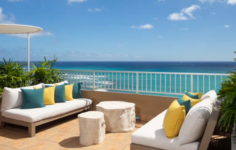 A beautiful sunset over a calm ocean with vibrant orange and pink hues reflecting on the water at the Coconut Club in the Twin Fin Hotel