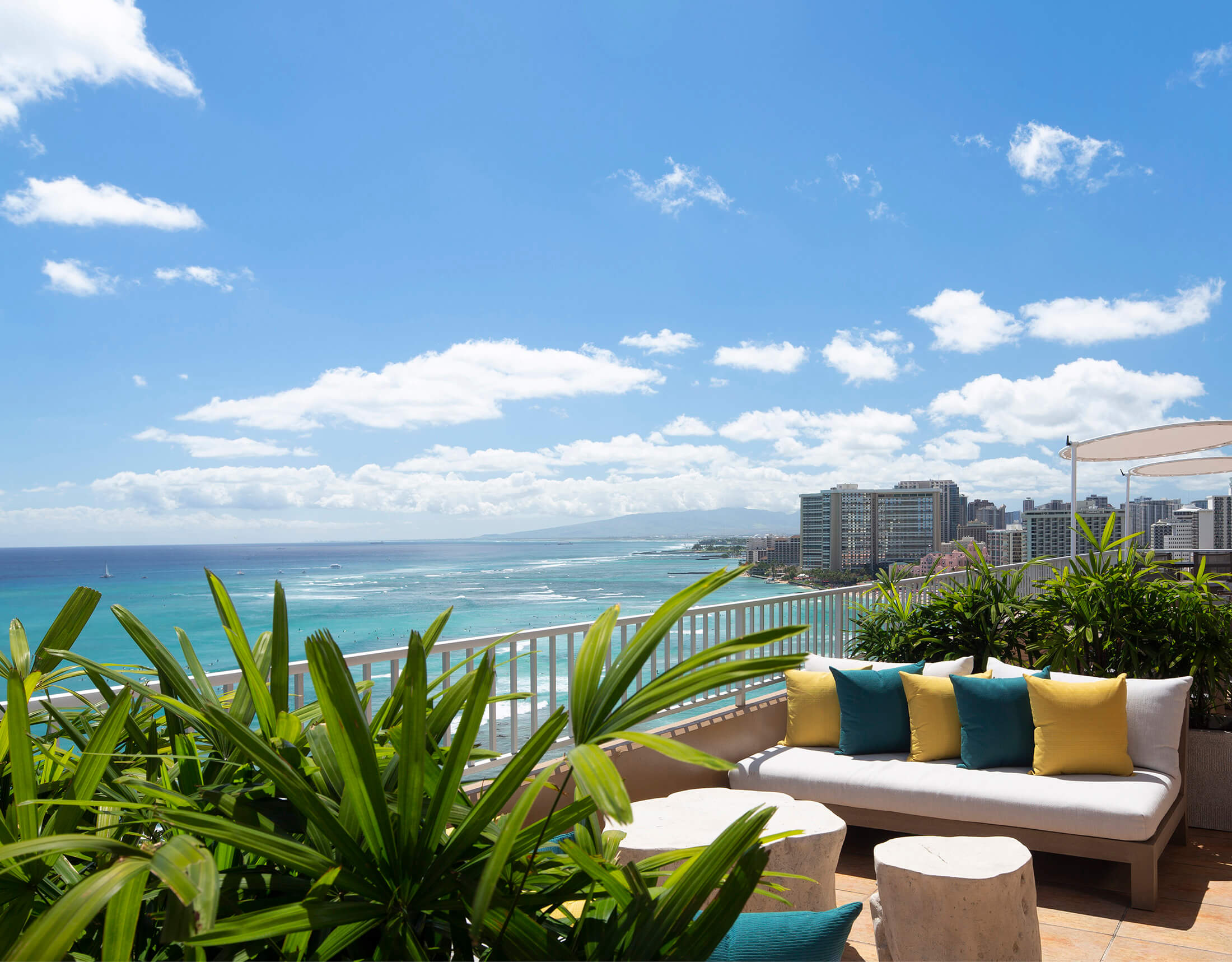 A balcony with outdoor furniture and a view of the ocean.
