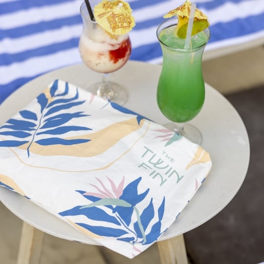 Drink with cocktail umbrellas with Twin Fin logo bag