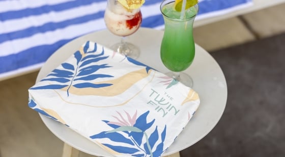Drink with cocktail umbrellas with Twin Fin logo bag