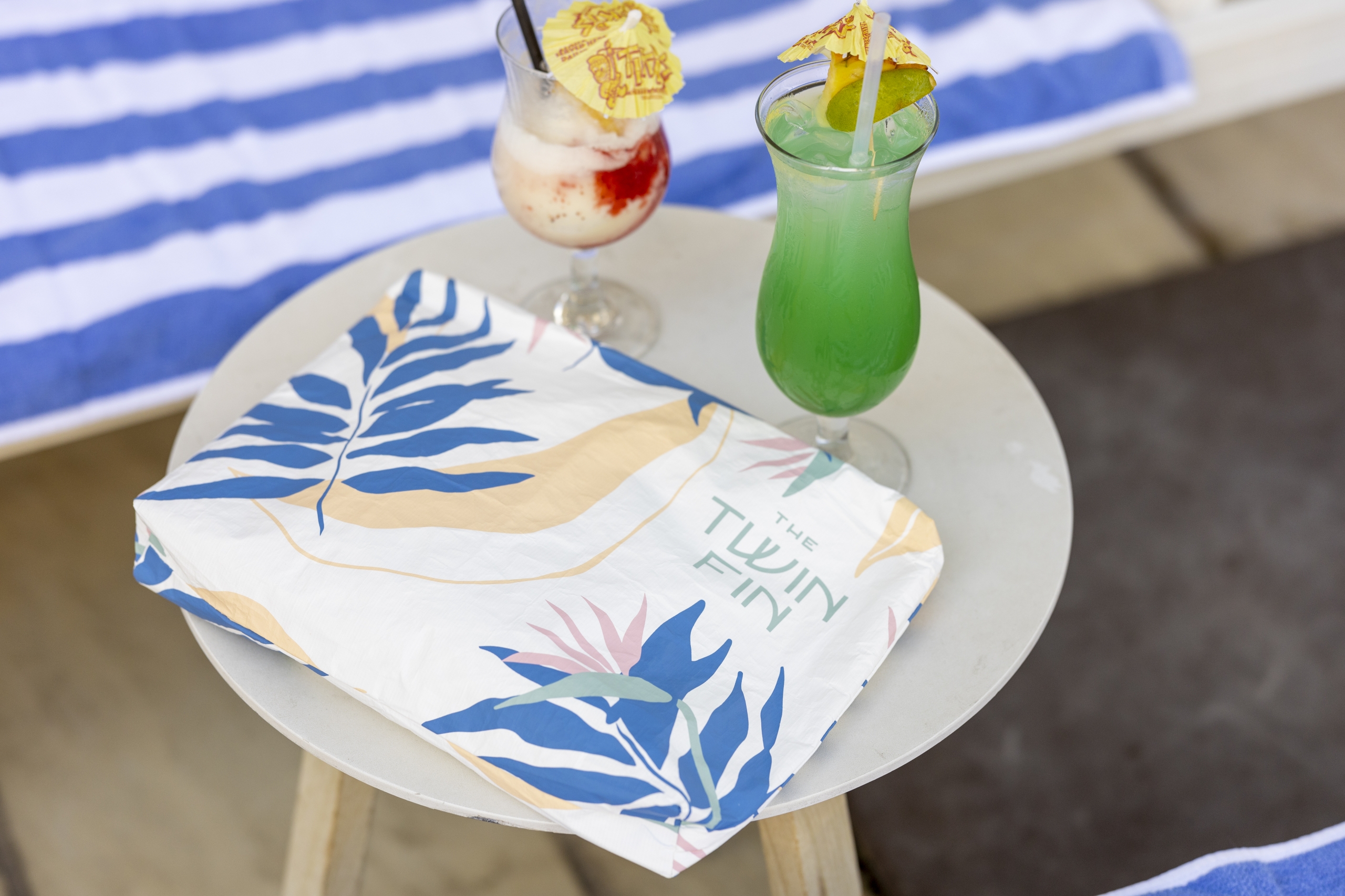 Drink with cocktail umbrellas with Twin Fin logo bag