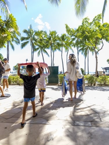 Mother and sons walking with beach gear