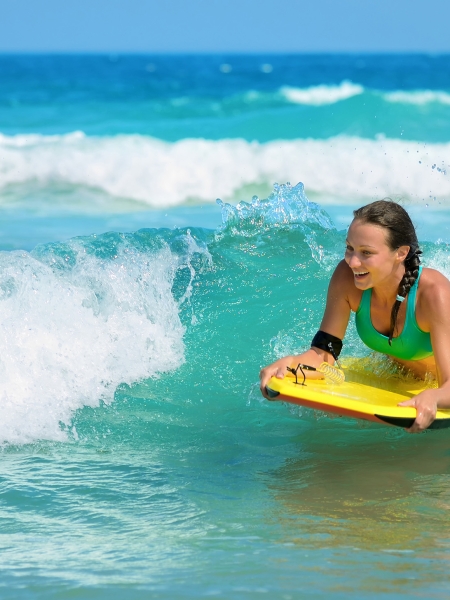 Young woman bodyboarding in ocean