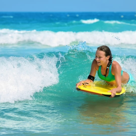 Young woman bodyboarding in ocean