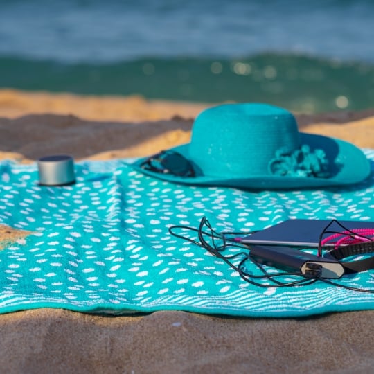 Swimming outfit and hat laying on the beach of Beach Candi Waikiki