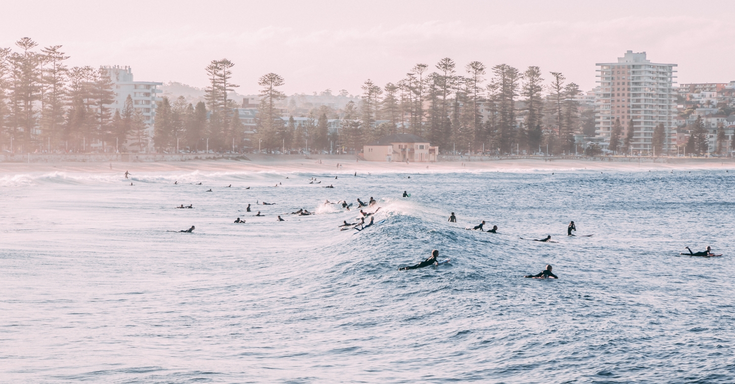 Manly Beach verdant hills, a clear sky, and a peaceful lake that reflects the surrounding natural beauty.